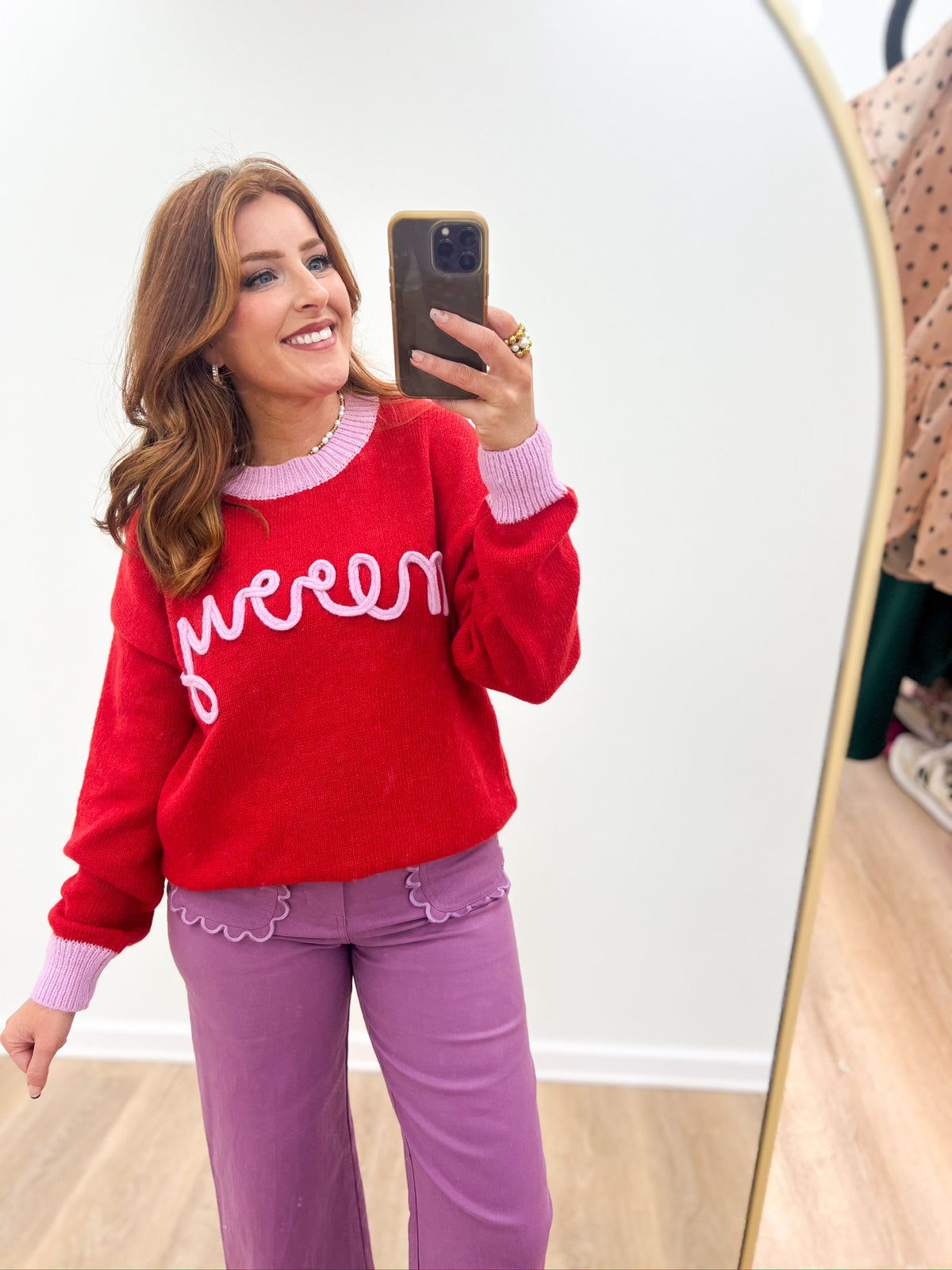 Red crewneck knit sweater with white "merry" script and ribbed cuffs