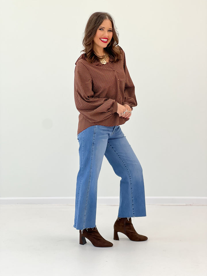 Burgundy plaid blouse featuring a ruffled collar and long sleeves