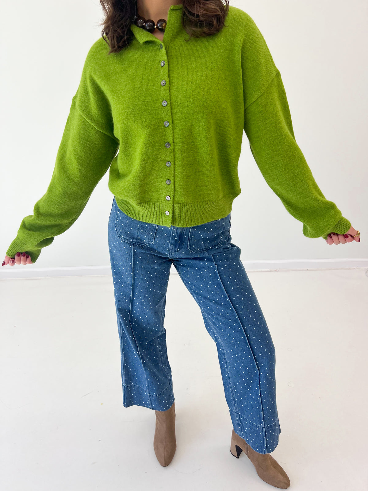 Pea green fold-over neck button-front sweater with long sleeves and ribbed cuffs