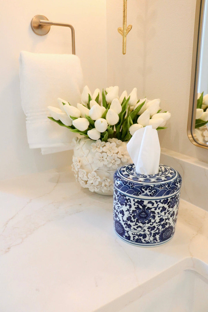 Blue and white patterned ceramic tissue vessel with tissue paper protruding