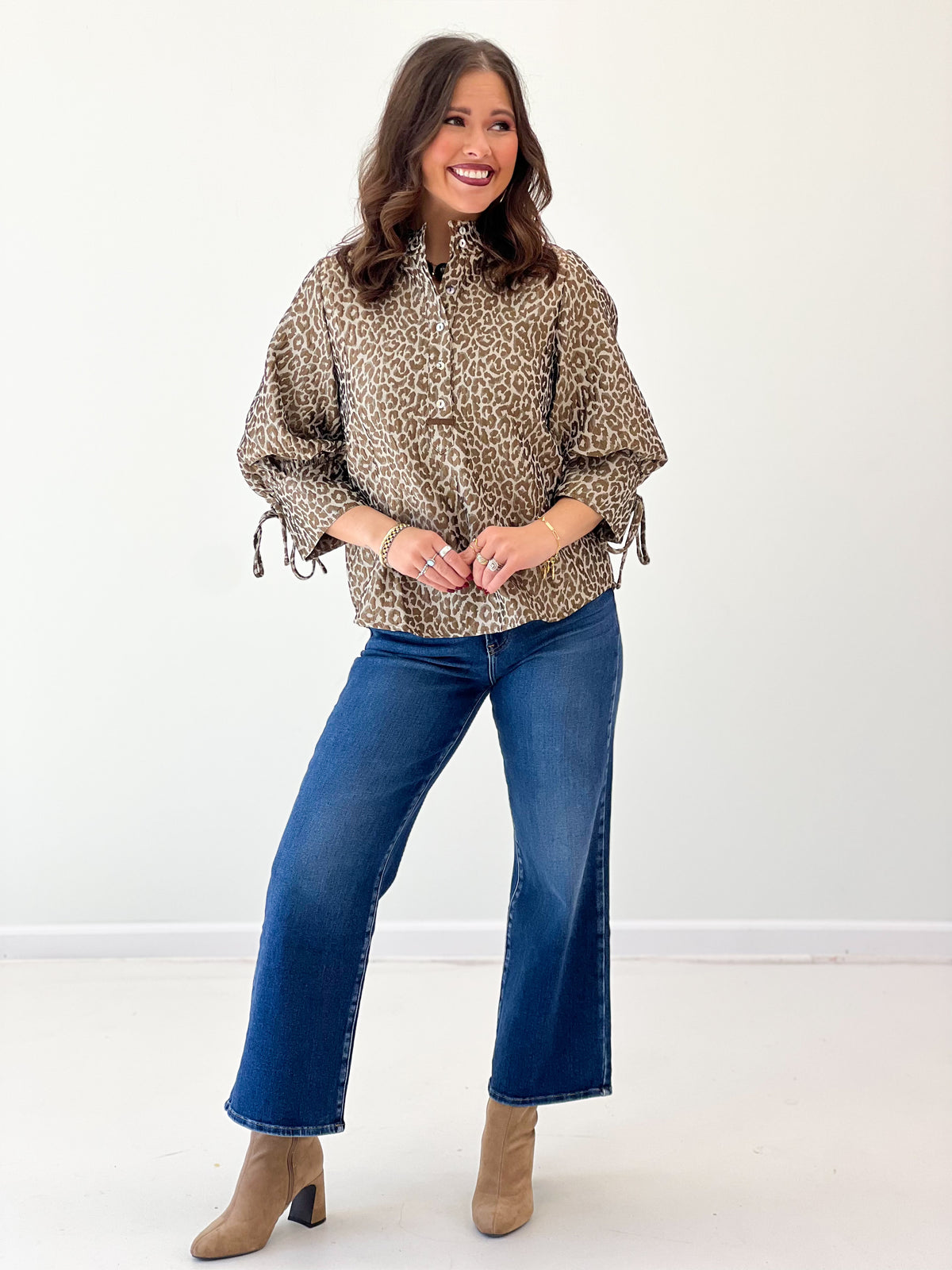Taupe leopard jacquard button-up top with puff sleeves and tied cuffs.