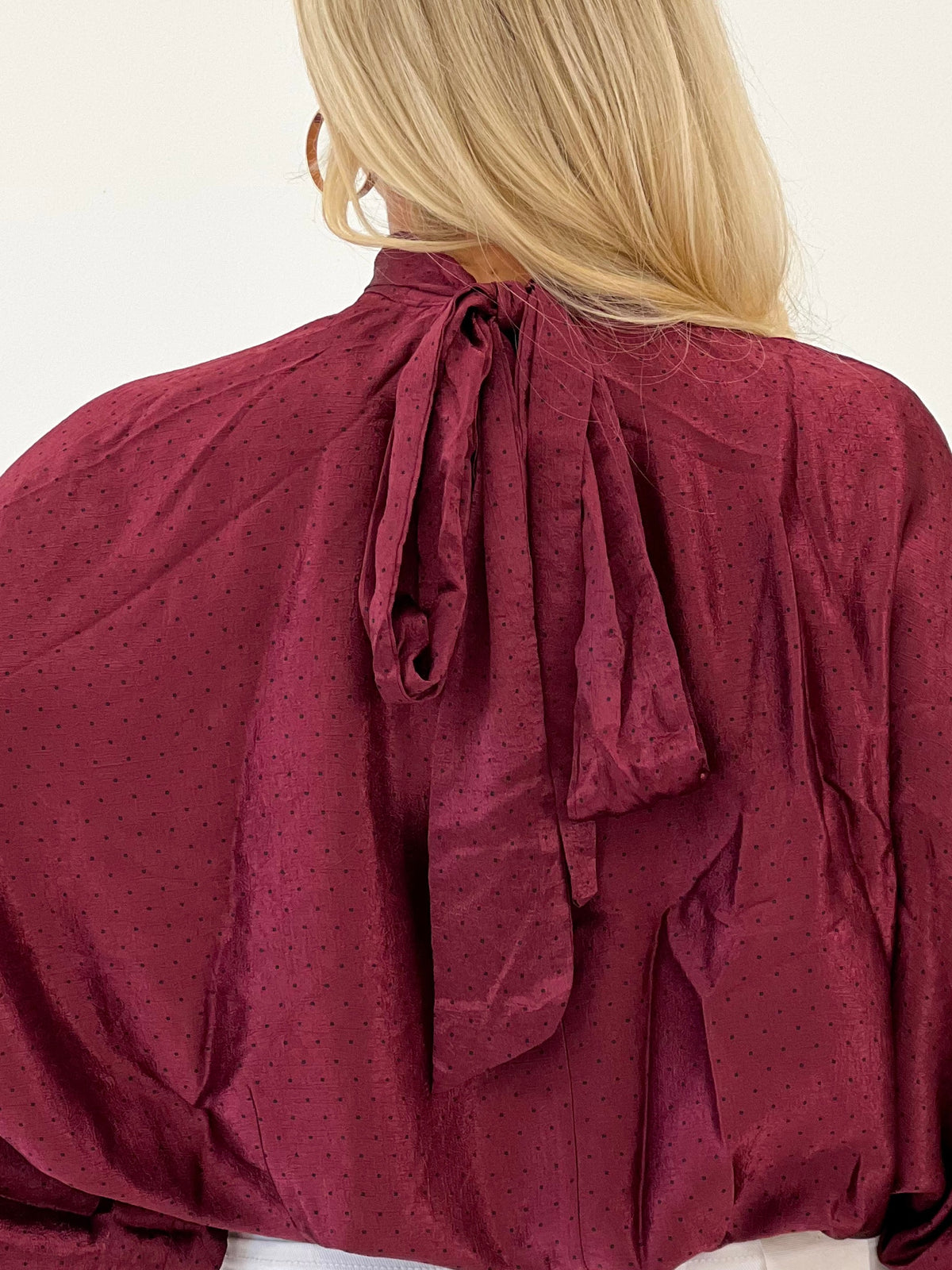 Burgundy polka dot high-neck blouse with tie-back bow and long puff sleeves