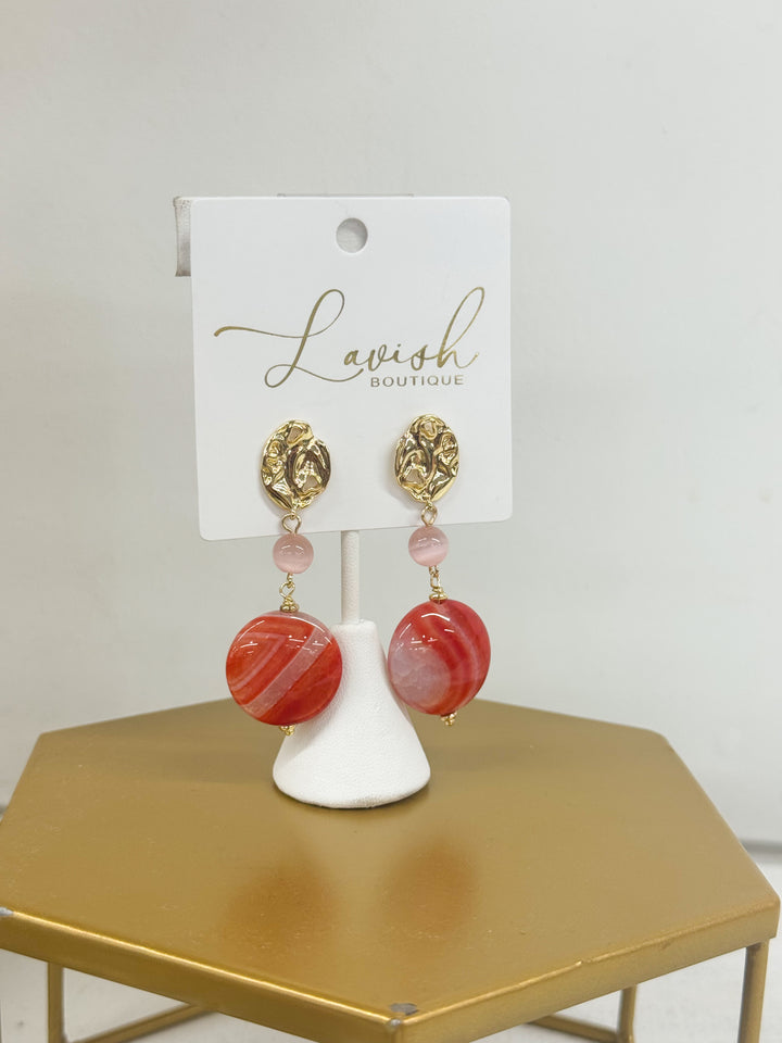 Gold drop earrings with pink beads and red striped round pendants
