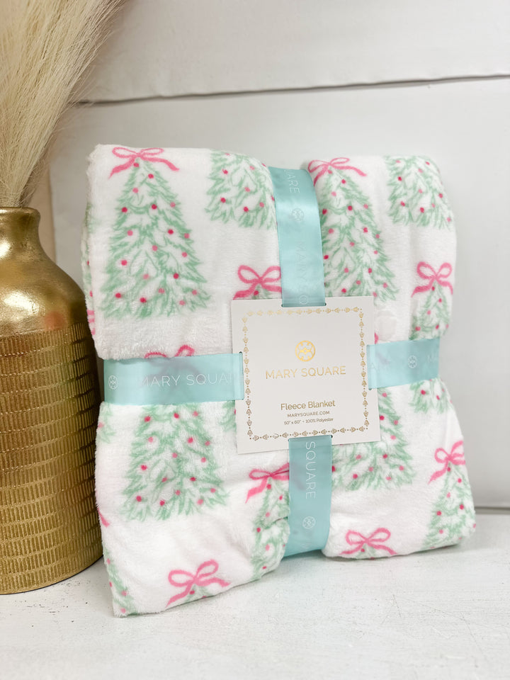 Fleece blanket with quilted look; green tree print and pink bows on white