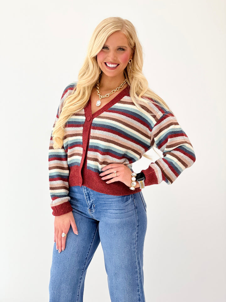 Cropped striped cardigan featuring burgundy button-front V-neck and ribbed hem