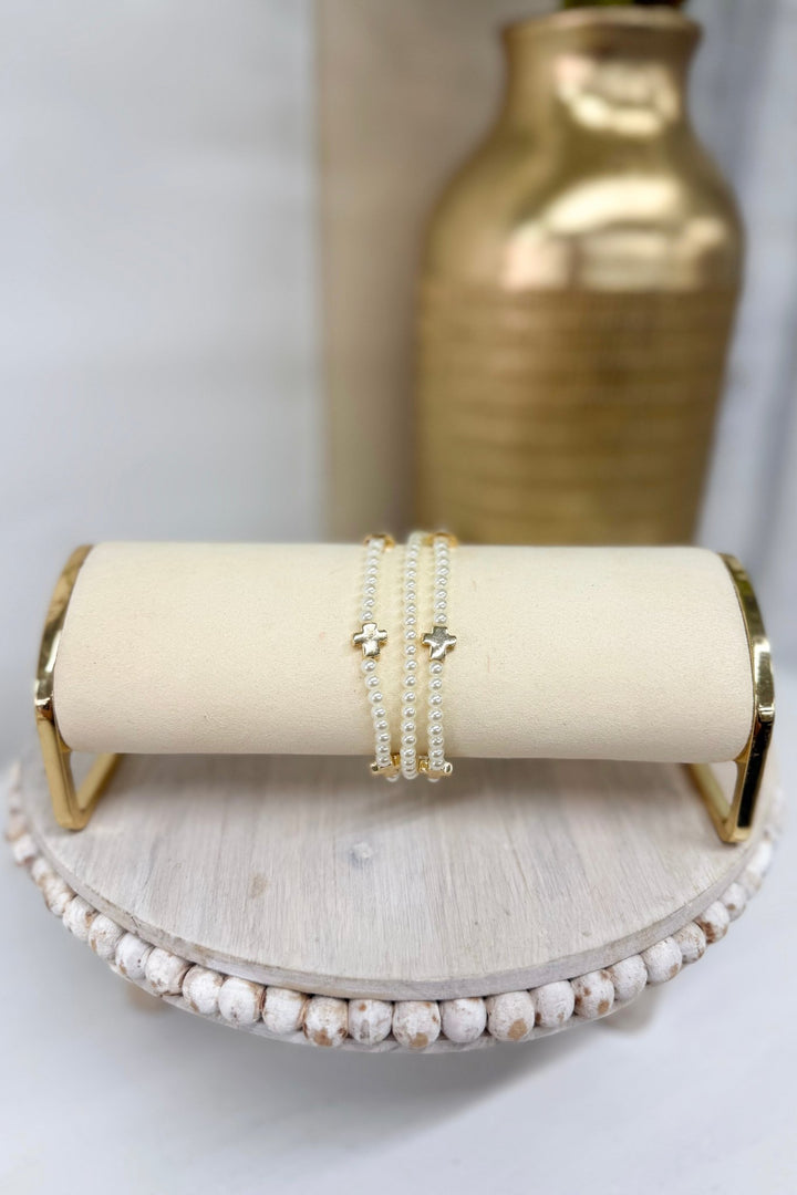 Three-row cream pearl bracelet with a gold cross