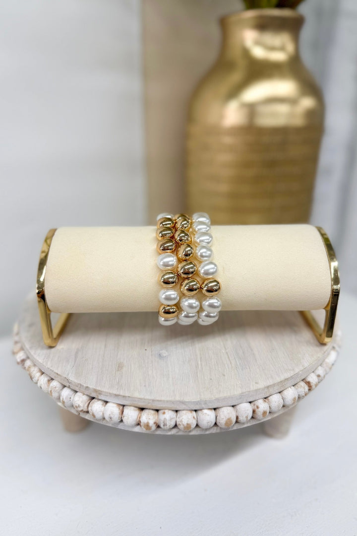 Three-row bracelet of cream oval pearls and gold balls