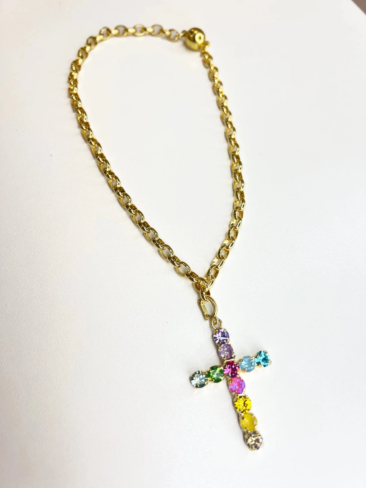 Confetti crystal necklace centered on a gold cross
