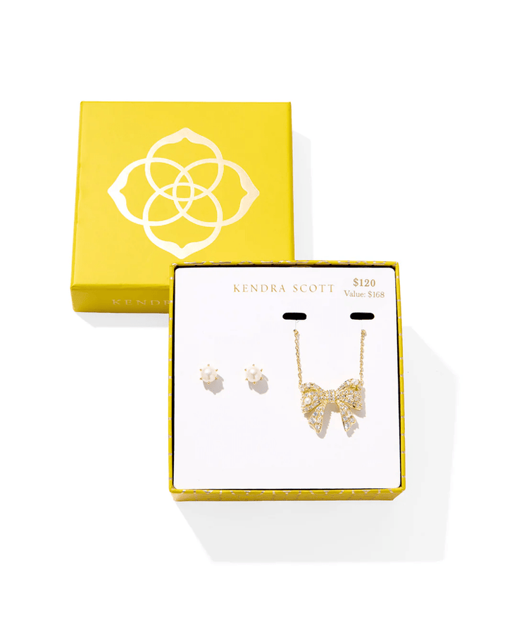 Gold jewelry set with bow earrings and a white beaded necklace