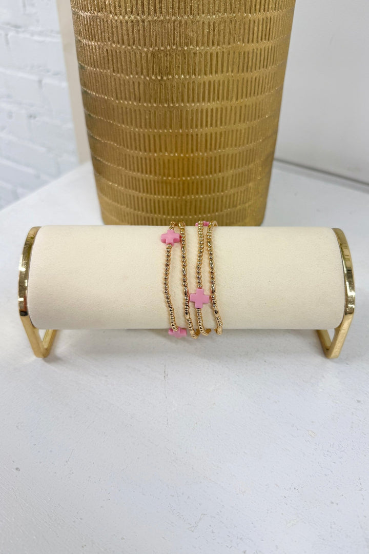Pink four-row beaded bracelet with a gold cross