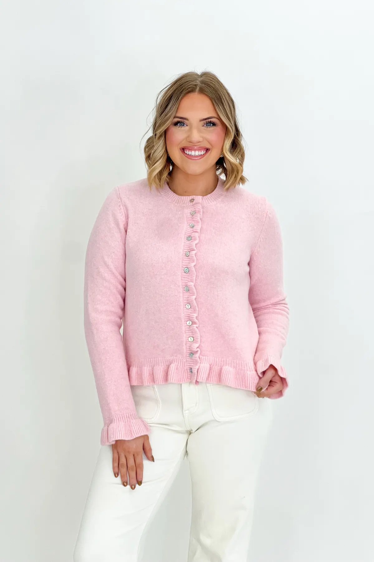 Pink knit cardigan with ruffle front buttons and ribbed hem cuffs