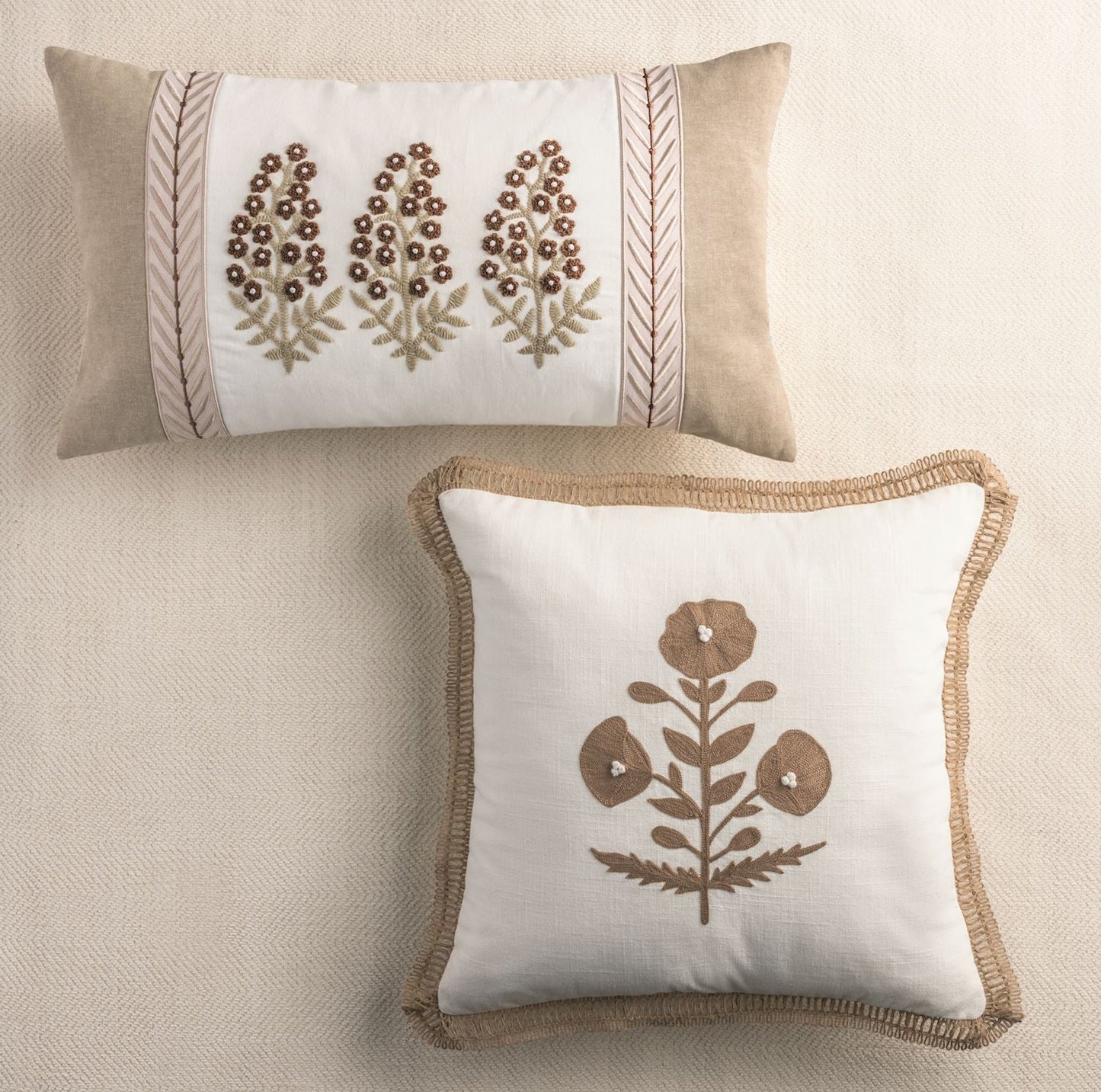Ribbon-trimmed cream throw pillow with floral embroidery