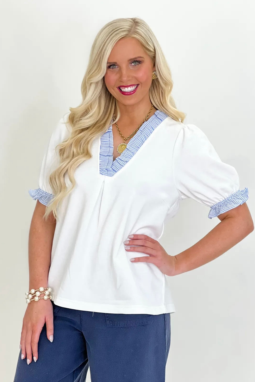 Off-white V-neck top with light-blue ruffle trim and short puff sleeves