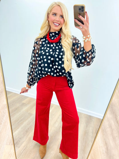 Black polka dot high-neck long-sleeve blouse with red contrast collar