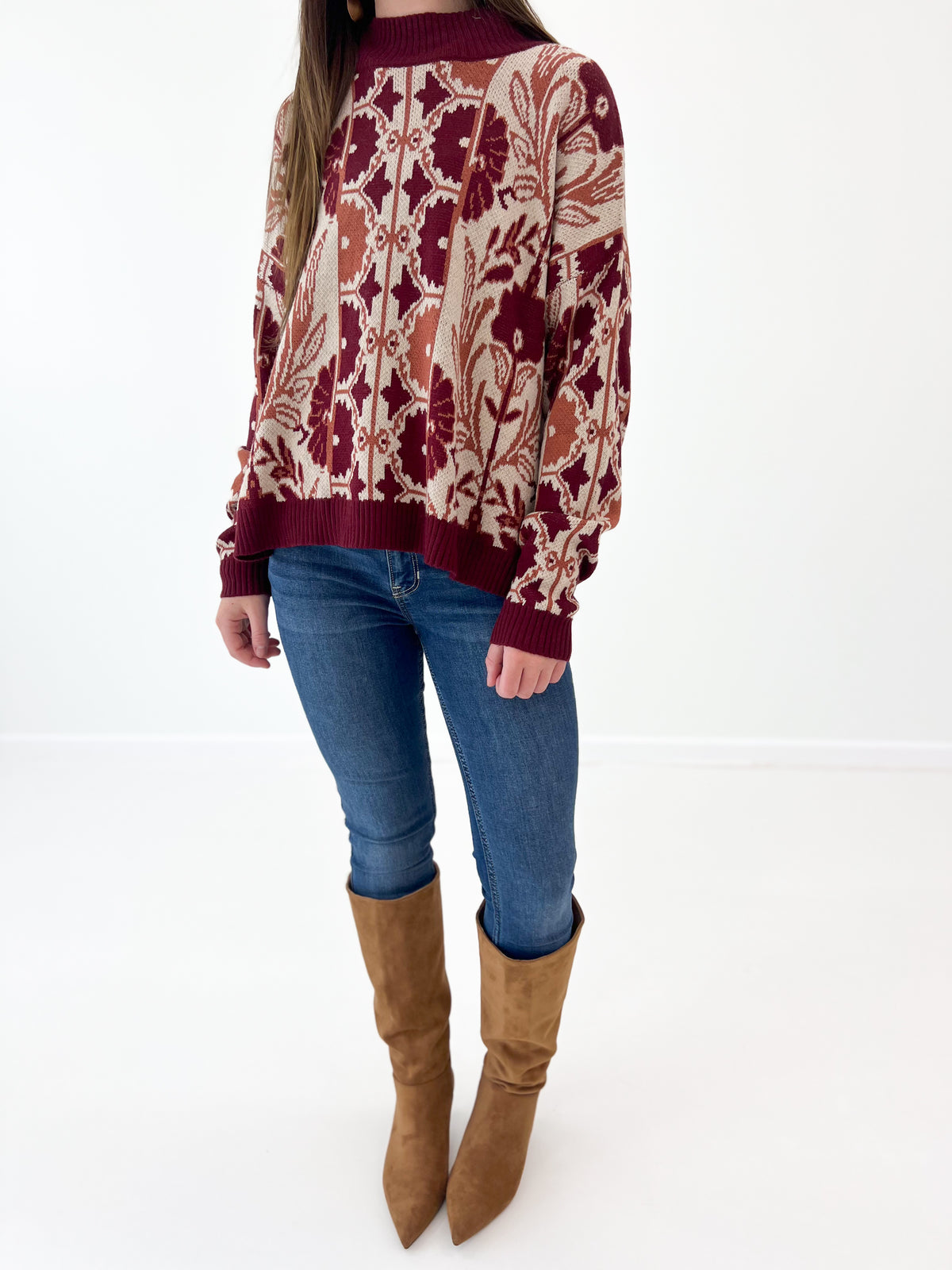 Wine knit sweater detail: tapestry floral motif and ribbed cuffs at hem