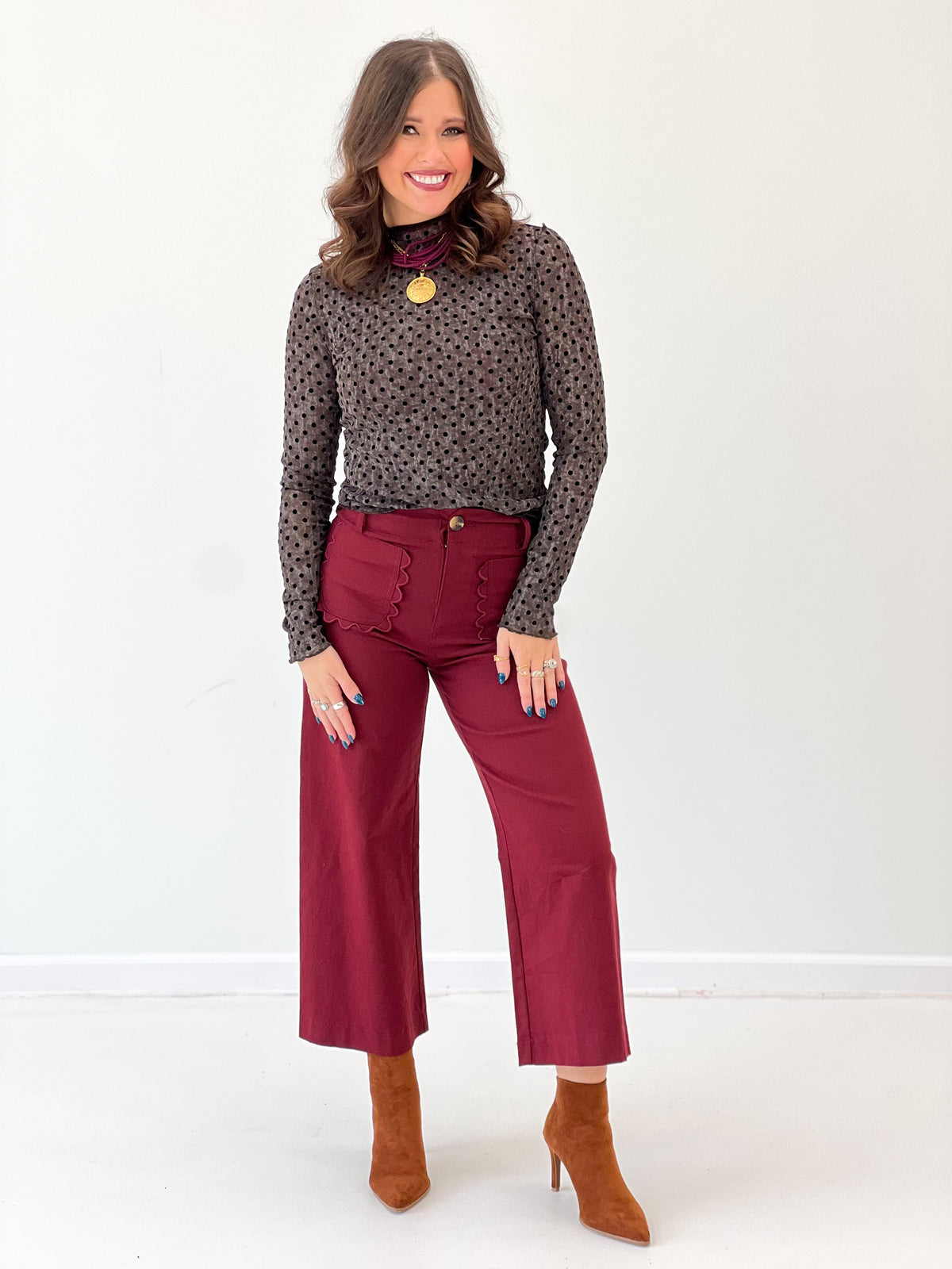 Black polka dot mock-neck long-sleeve top, full-length front with small allover dots.
