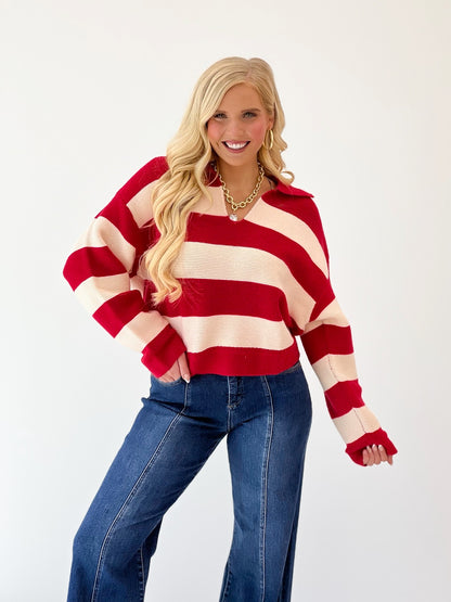 Red and ivory striped V-neck sweater with long sleeves and ribbed cuffs