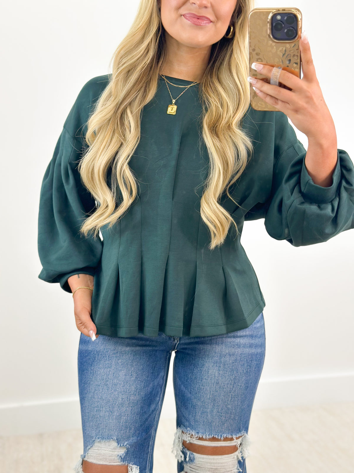 Forest green gathered long-sleeve peplum top with round neckline and pleated hem