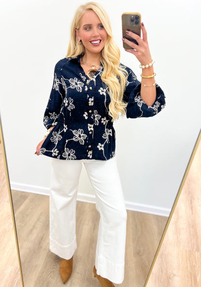 Navy floral button-front top with long sleeves and decorative front placket