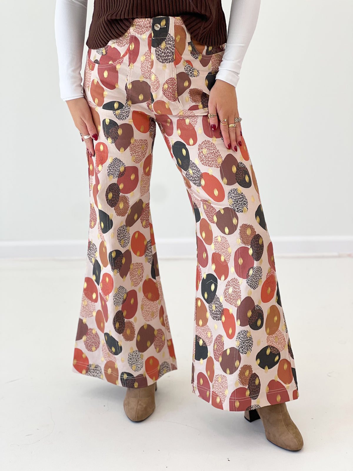 Wide-leg pants close-up with multicolor abstract foil print, bisque base