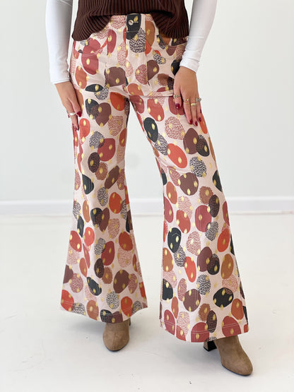 Wide-leg pants close-up with multicolor abstract foil print, bisque base