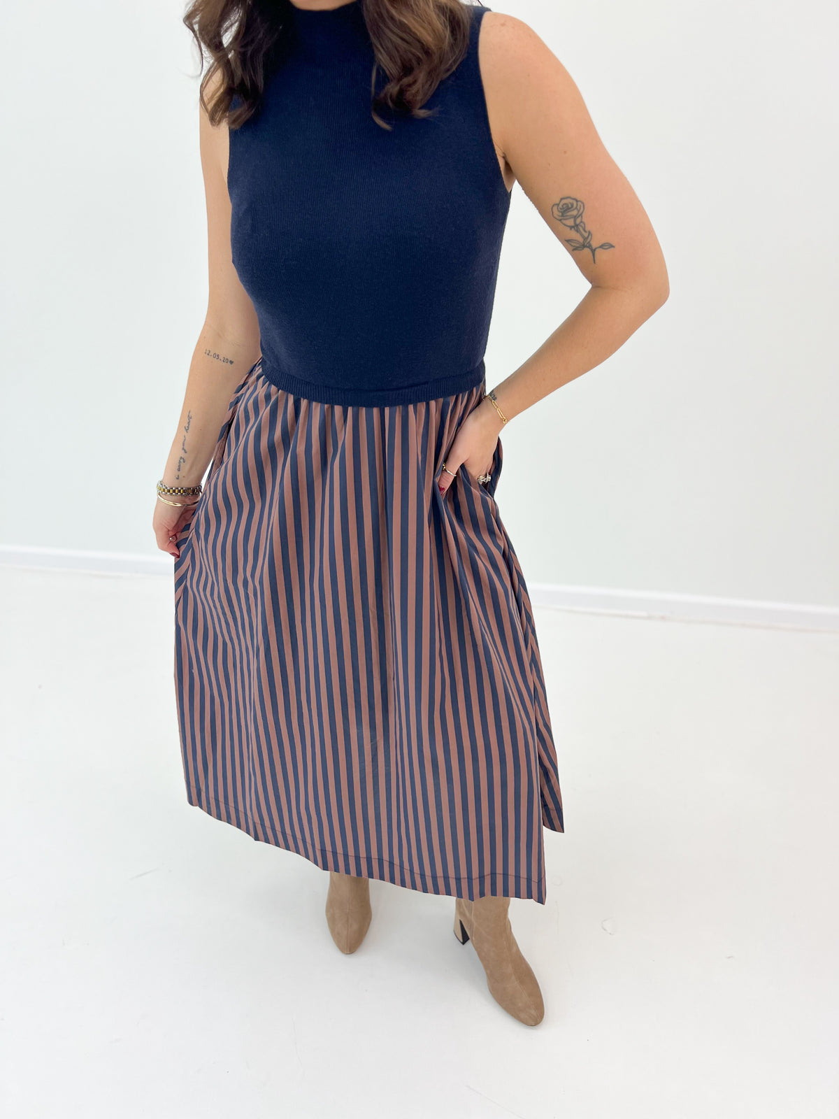 Navy sleeveless midi dress with striped pleated skirt and high neckline