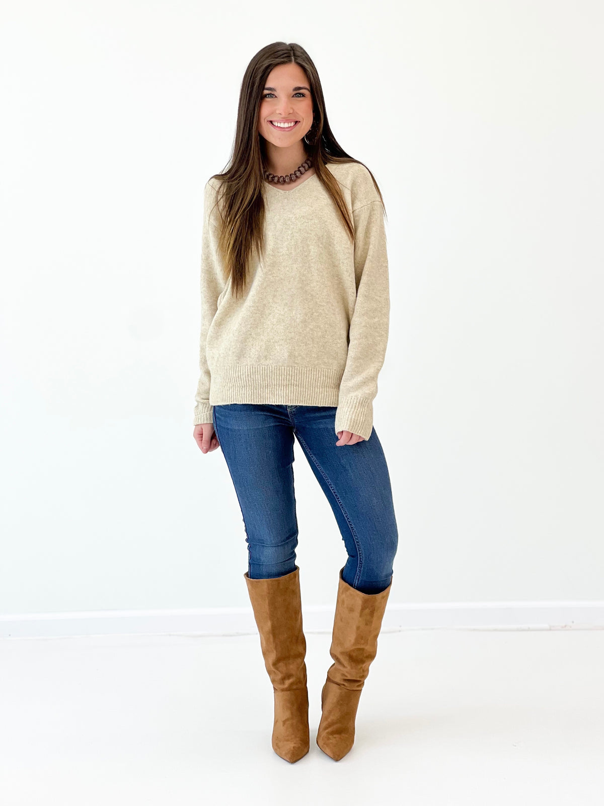 Oatmeal v-neck long-sleeve knit sweater with ribbed hem, standing full-body
