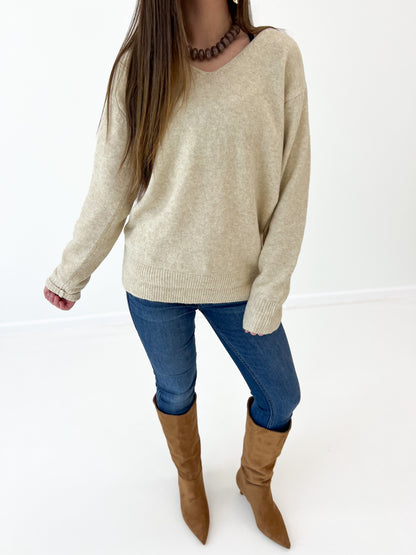 Oatmeal v-neck long-sleeve knit sweater close-up, ribbed neckline and cuffs