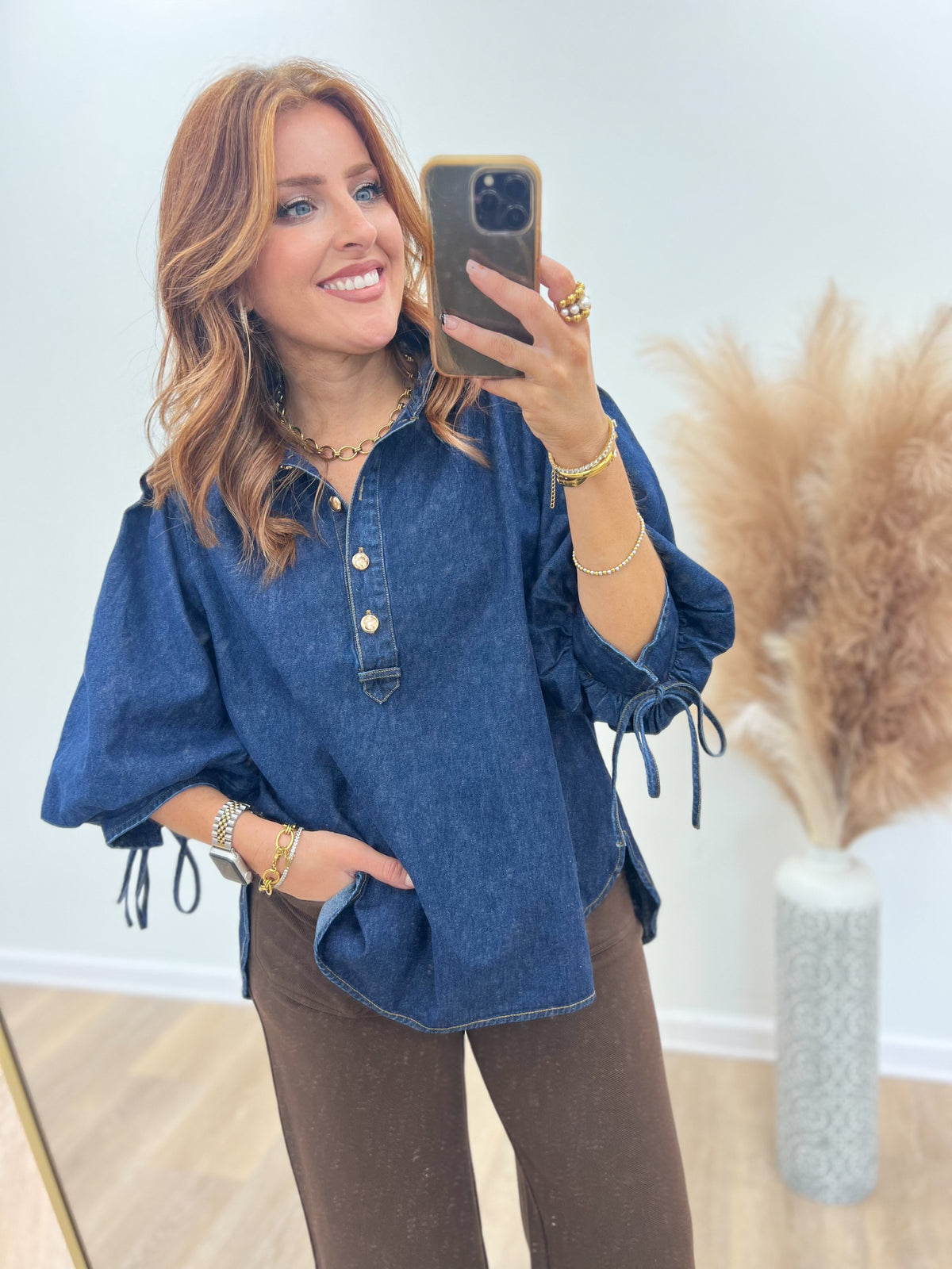 Dark denim puff-sleeve top detail: button placket and drawstring cuffs