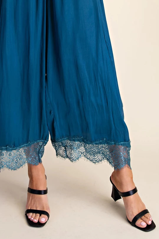Close-up of lace trim on teal cropped pants hem
