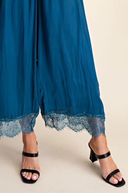 Close-up of lace trim on teal cropped pants hem