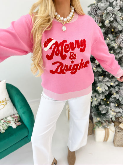 Pink crewneck sweater top with red Merry & Bright lettering, long sleeves