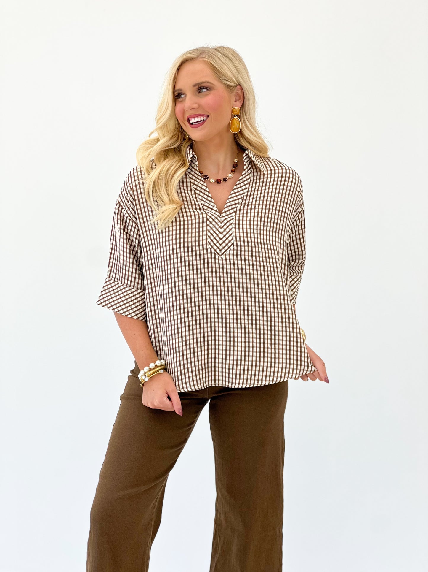 Brown and white gingham short-sleeve top with V-neck and loose, swingy fit.