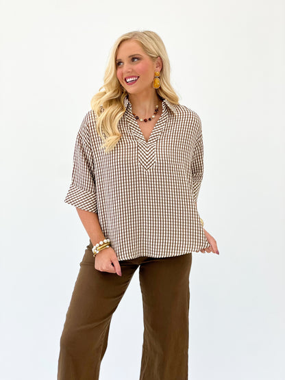 Brown and white gingham short-sleeve top with V-neck and loose, swingy fit.