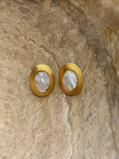 Gold-tone round hoop earrings with ribbed edges and white mother-of-pearl insets