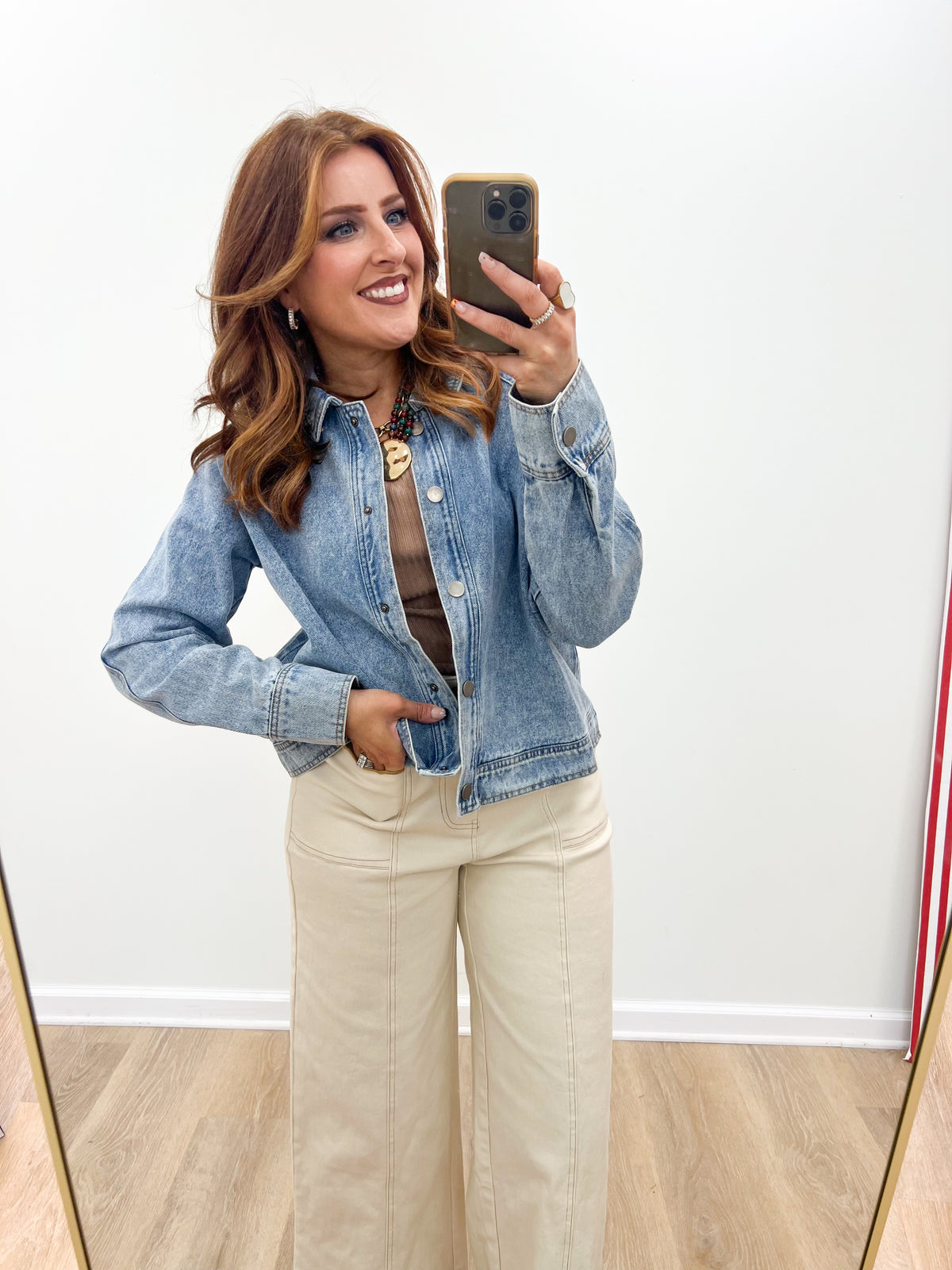 Light-wash cropped denim jacket with button front, flap pockets, and long sleeves