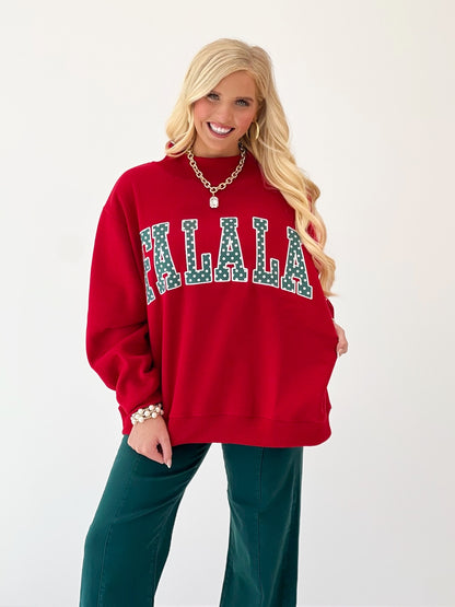 Red mock-neck sweatshirt with teal polka-dot applique 'FALALA' on the chest
