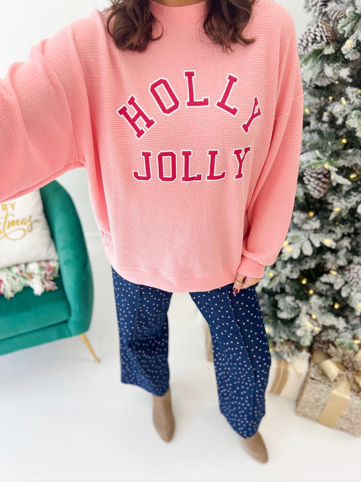 Pink knit Christmas sweatshirt detail: 'HOLLY JOLLY' front graphic