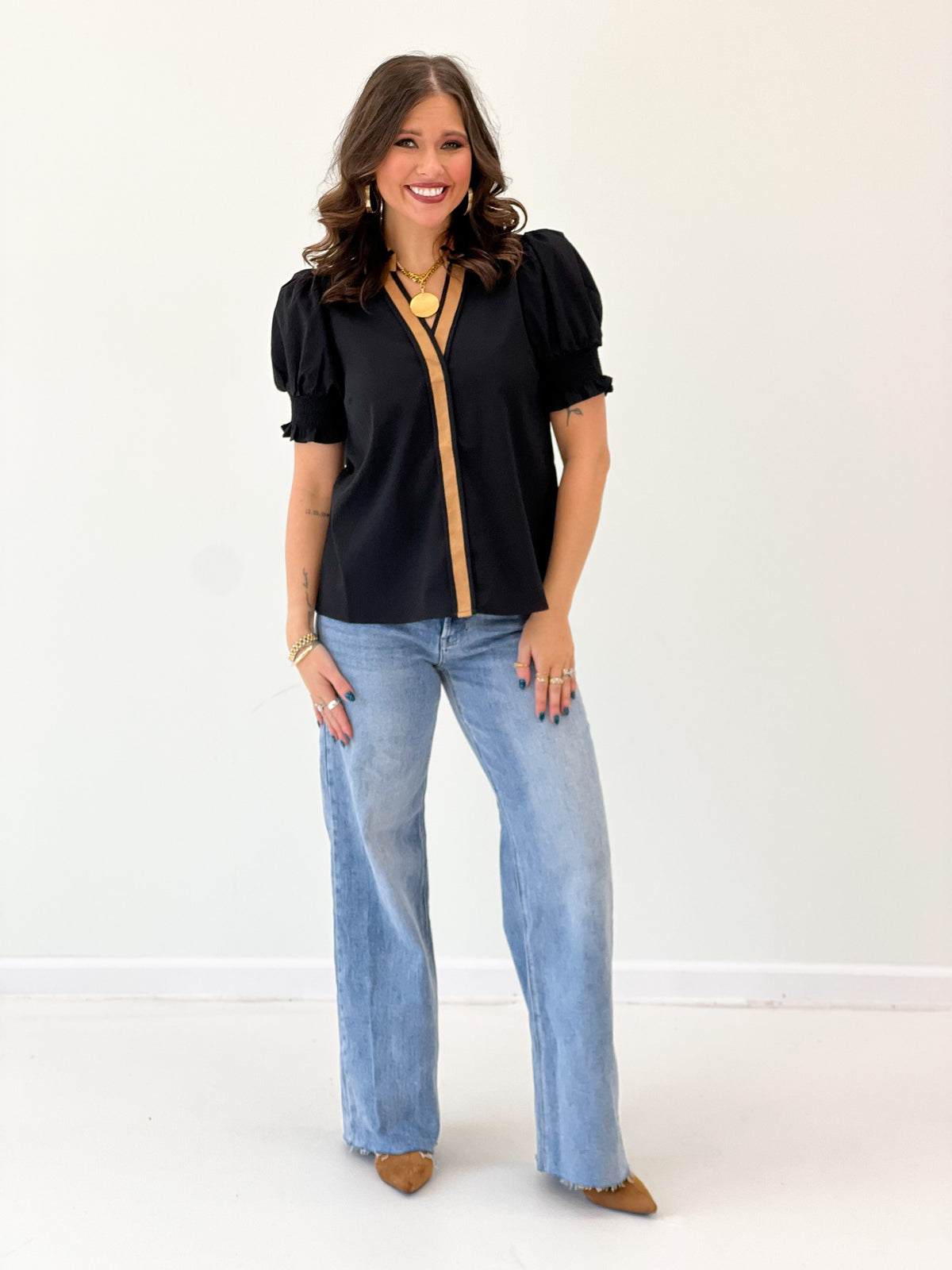 Black collared V-neck short-sleeve top with puff sleeves and front trim placket