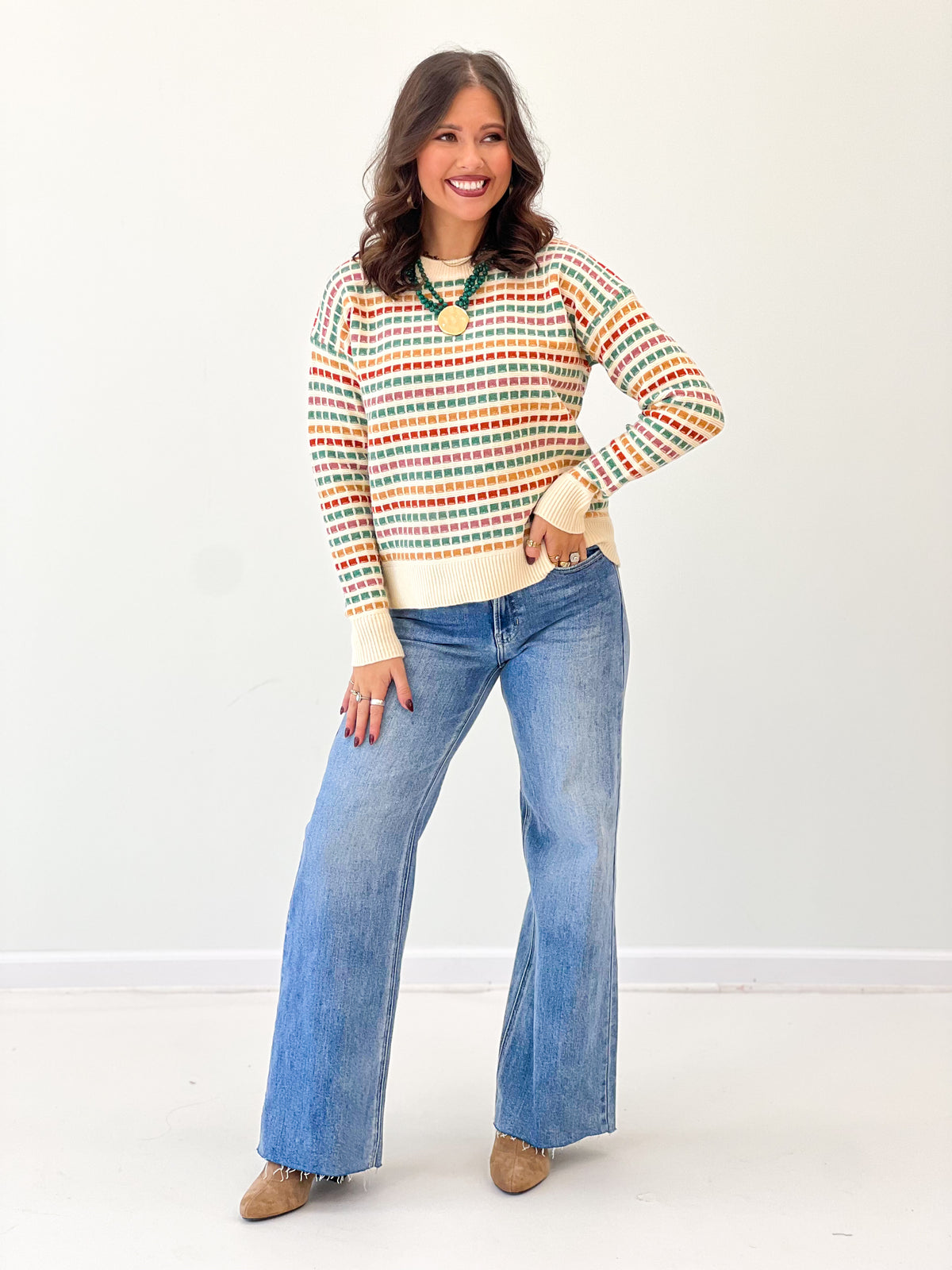 Multi-color striped sweater with patterned stripe knit and ribbed cream cuffs, crew neck