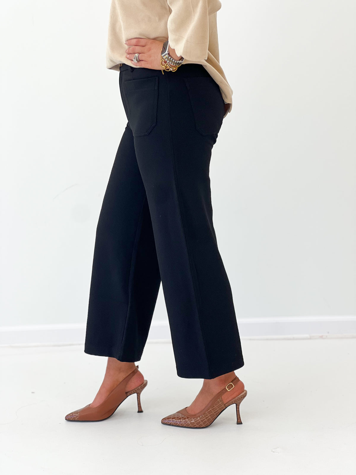 Black straight-leg trousers with front pockets and button closure, cropped wide-leg fit