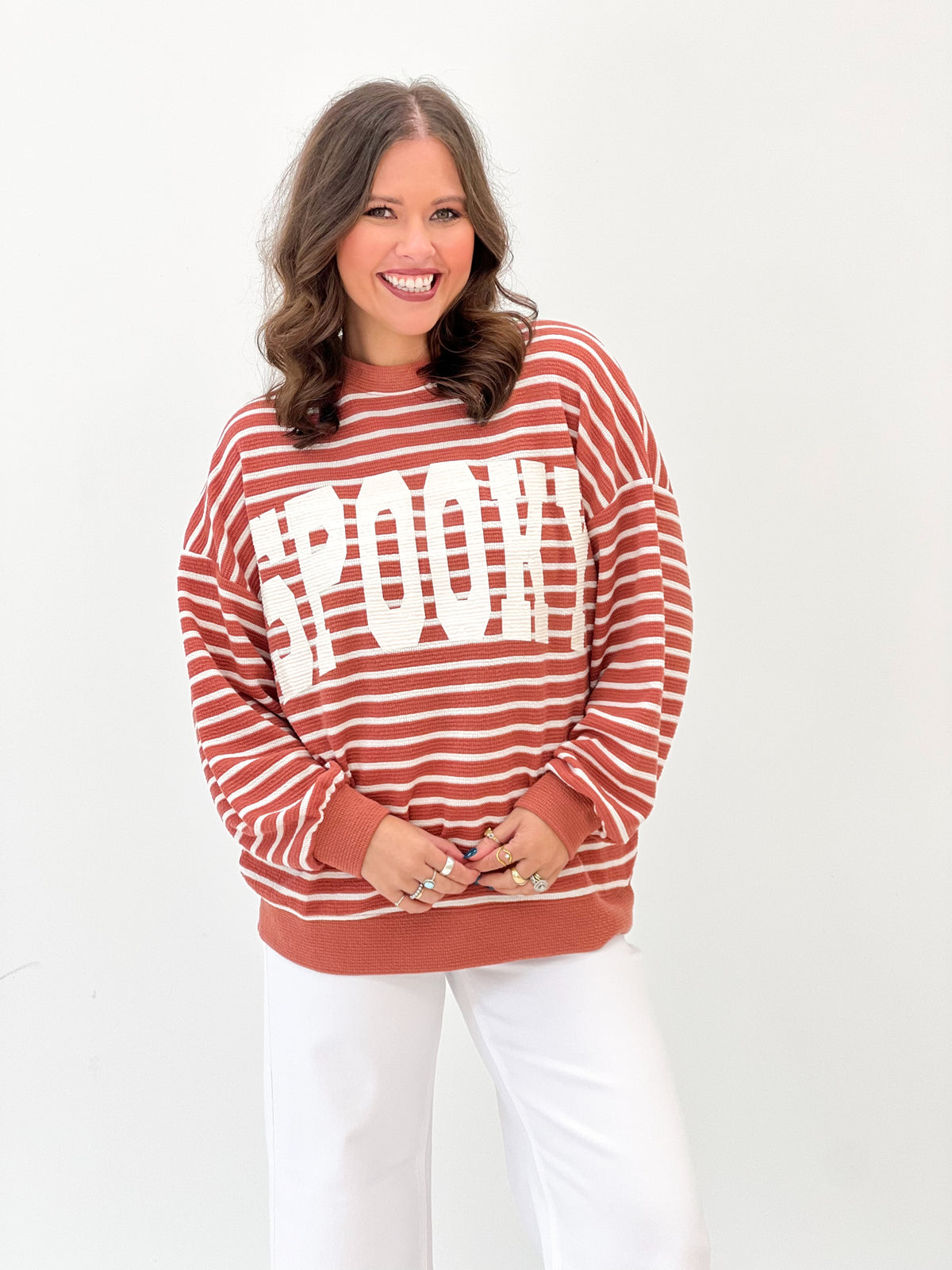 Rust red and white striped knit top with spooky graphic and crew neckline