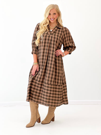 Brown-and-black checkered midi dress with open collar and roomy, draped fit