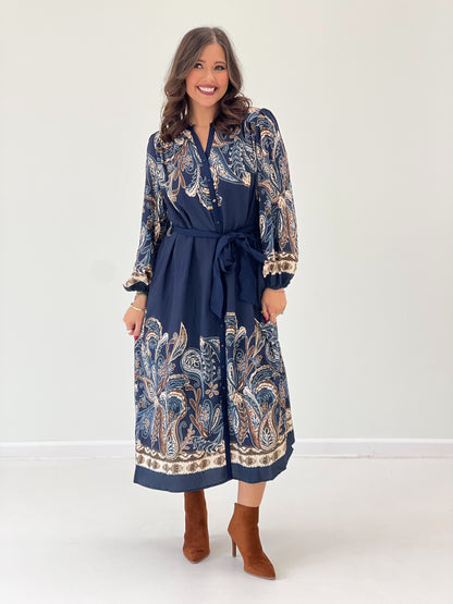 Navy abstract print long-sleeve dress with buttoned V-neck, tied waist belt, border hem