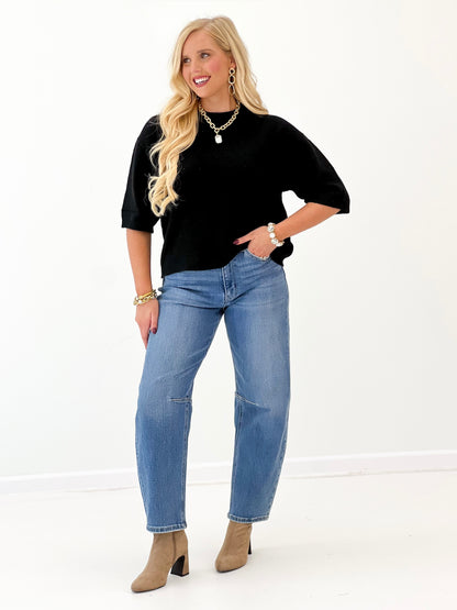 Heathered black crew neck sweater with short sleeves and loose drape