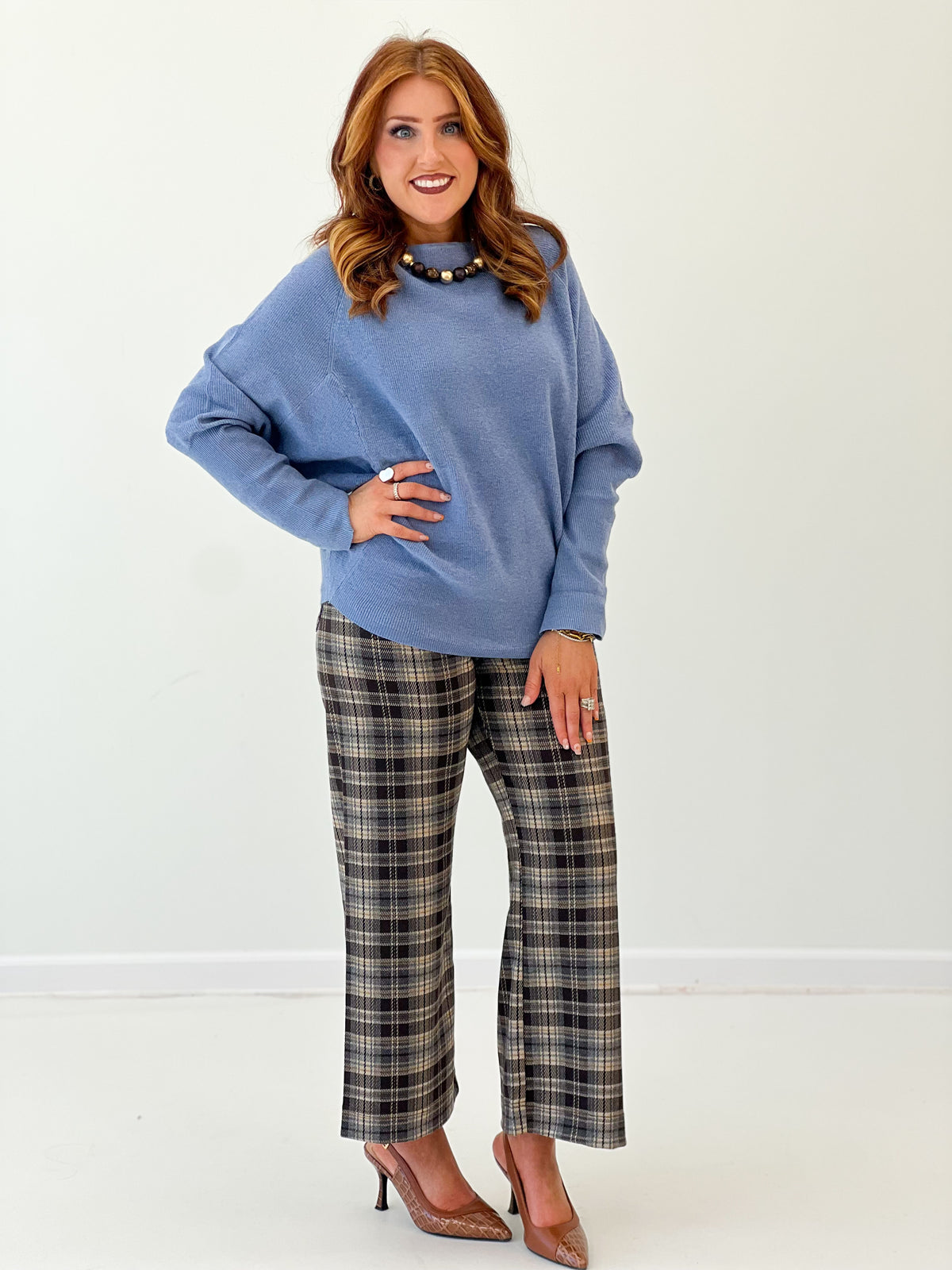 Blue boat-neck knit sweater top with long sleeves, relaxed side pose
