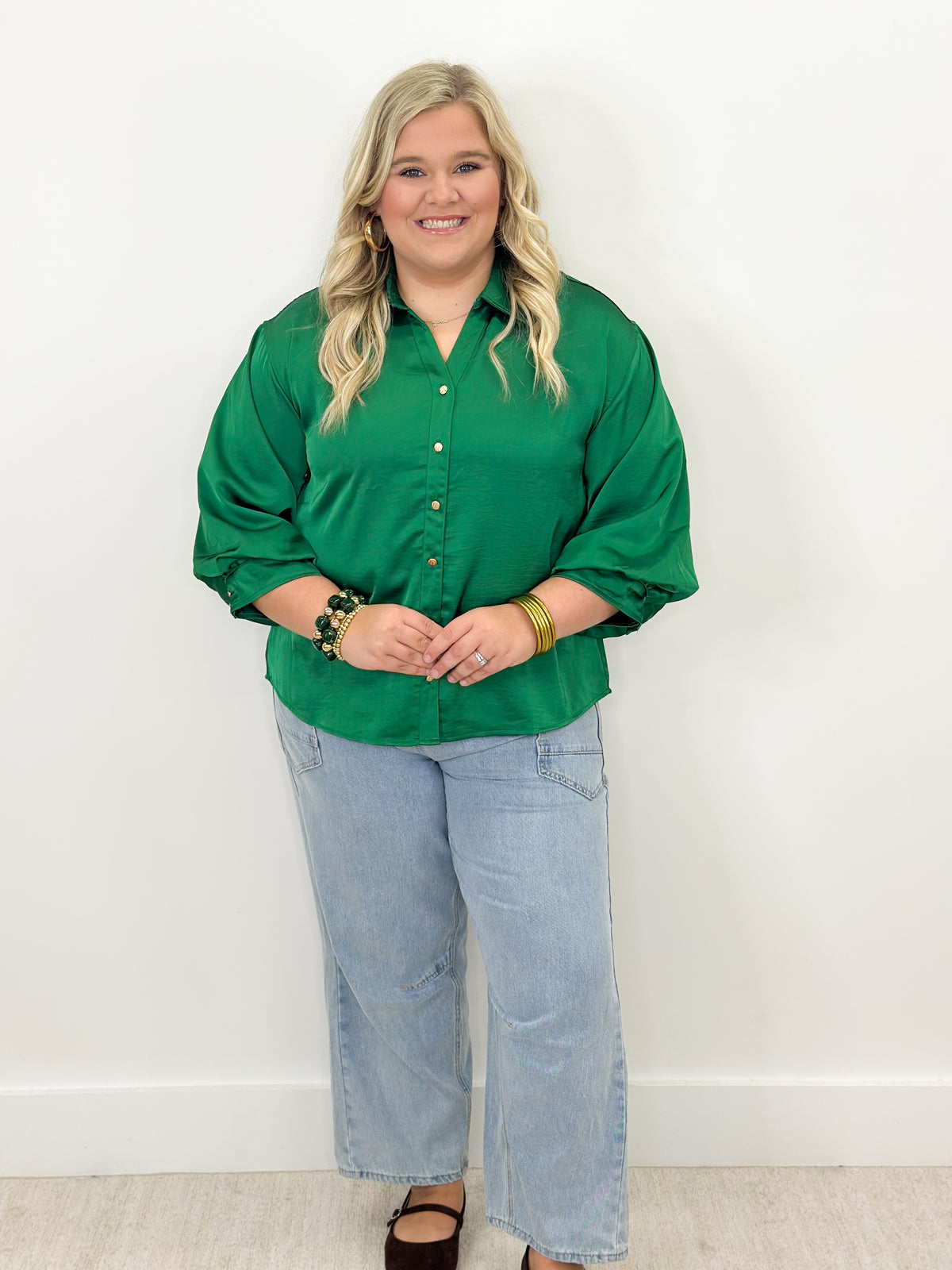 Green puff-sleeve button-front shirt with tassel detail at hem