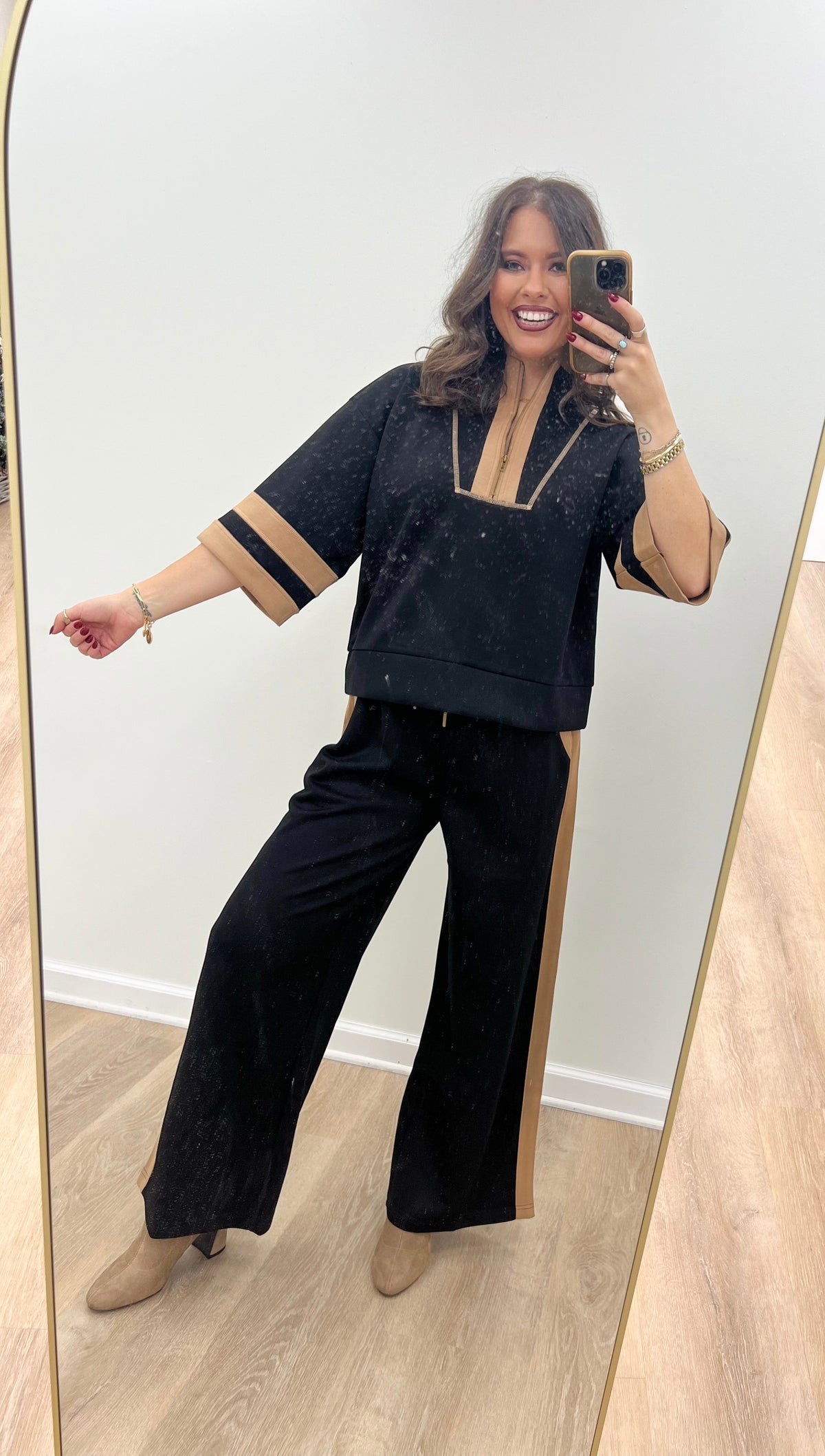 Black zip-up sweatshirt and wide-leg pants set with tan contrast stripe trim
