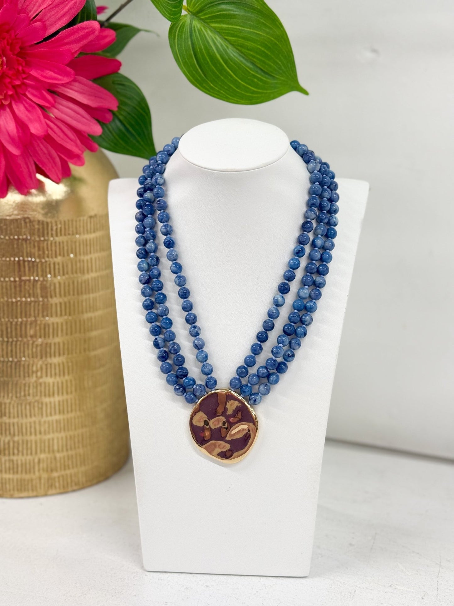 Three-strand beaded necklace with a hanging pendant
