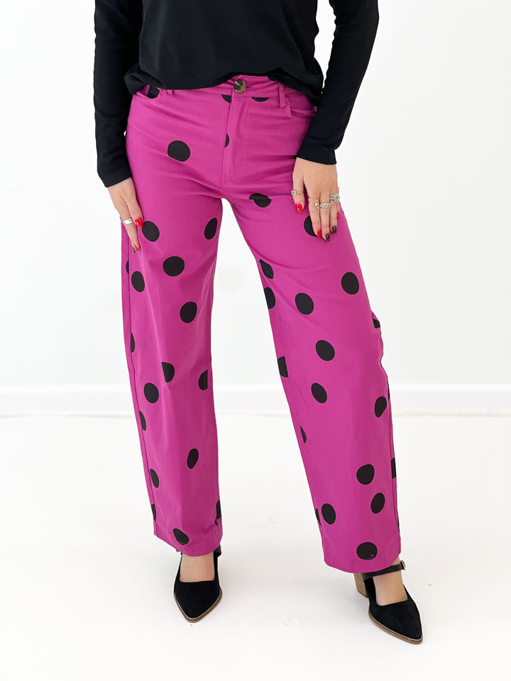 Magenta polka dot wide-leg stretch pants with black dots and front button closure